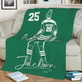 Green hockey throw blanket spread across a sofa with a seated player illustration and hockey stick