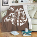 Brown football throw blanket draped over a sofa with bold helmeted player artwork