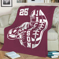 Maroon football throw blanket displayed on a sofa with bold player artwork