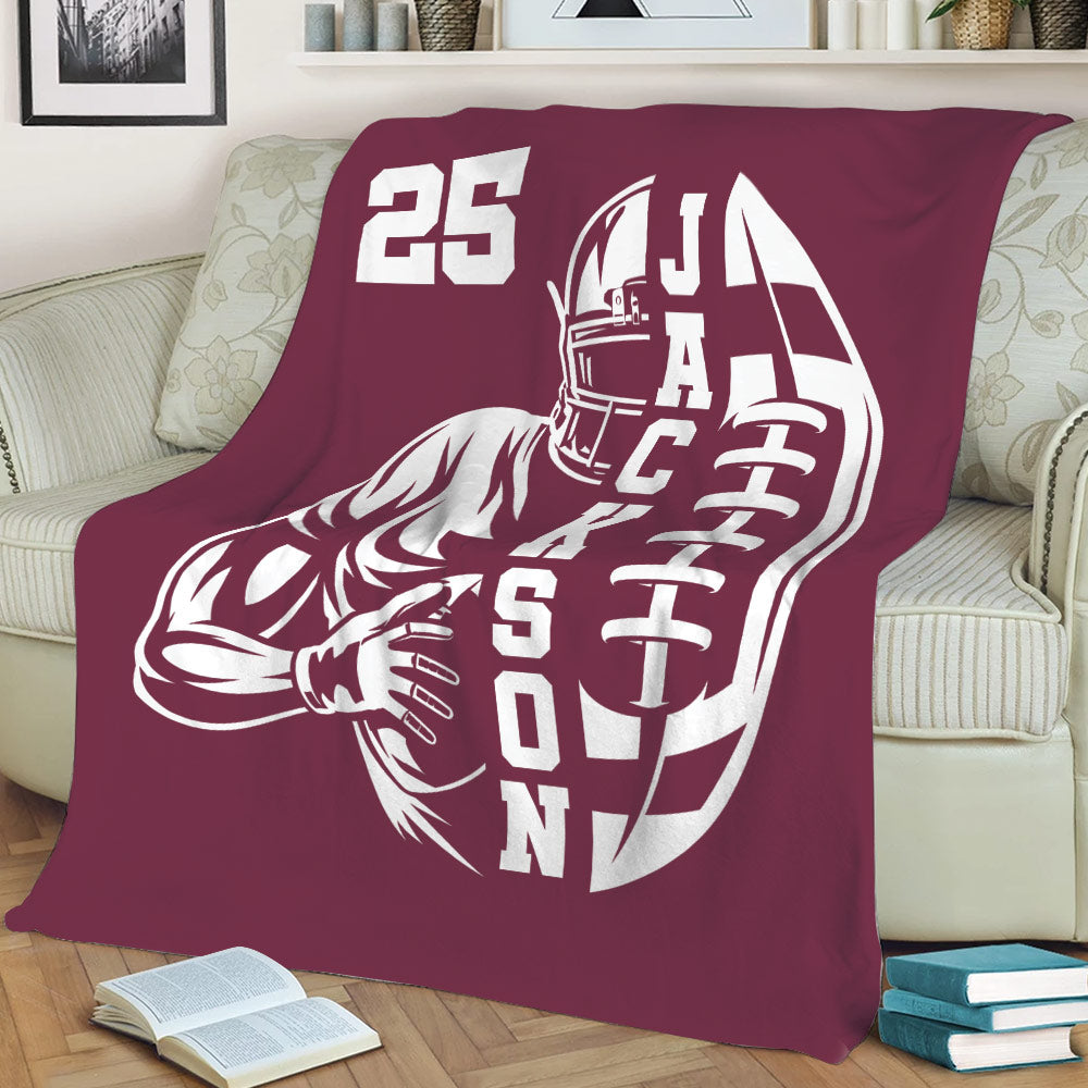 Maroon football throw blanket displayed on a sofa with bold player artwork
