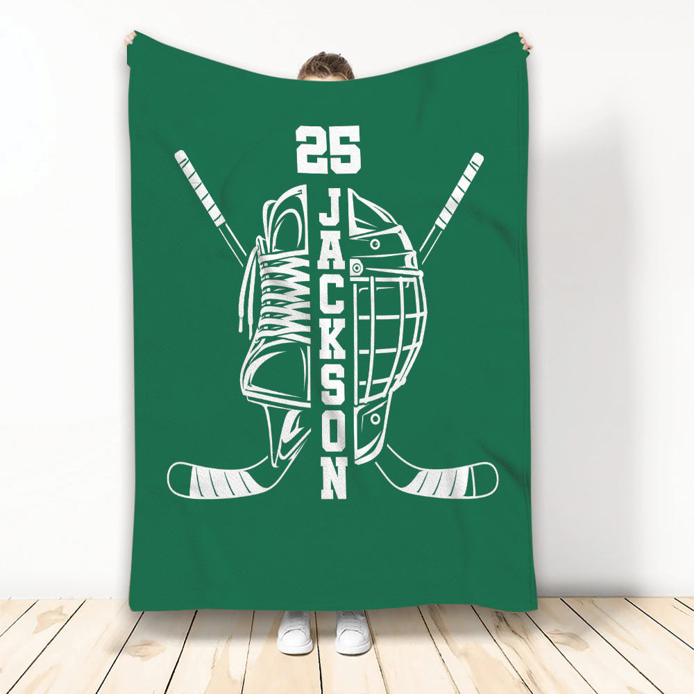 Green hockey throw blanket displaying a skate, helmet, crossed sticks, and white sports artwork
