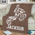 Brown motocross throw blanket styled on a sofa with large dirt bike rider artwork