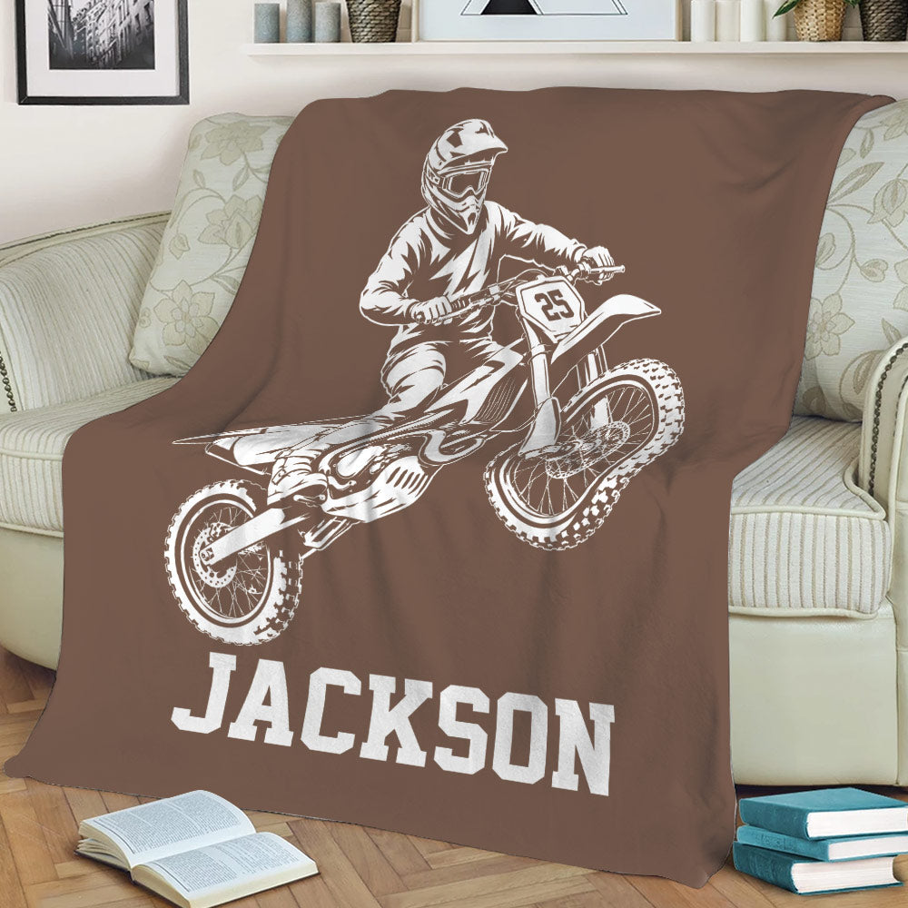 Brown motocross throw blanket styled on a sofa with large dirt bike rider artwork