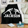 Wrestling blanket draped over a sofa with bold white grappler silhouettes on black