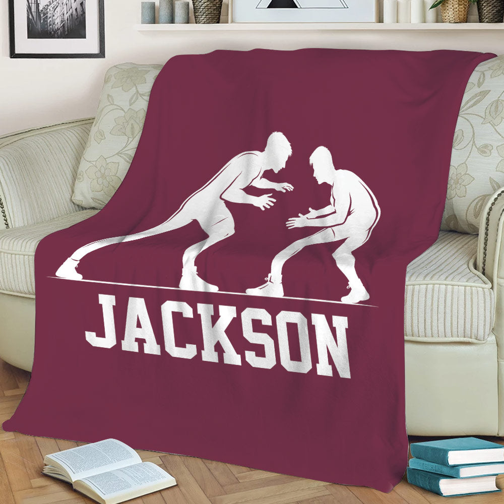 Maroon wrestling blanket displayed on a sofa with large white grappler artwork