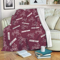 Maroon wrestling blanket draped over a couch with repeating grappling artwork