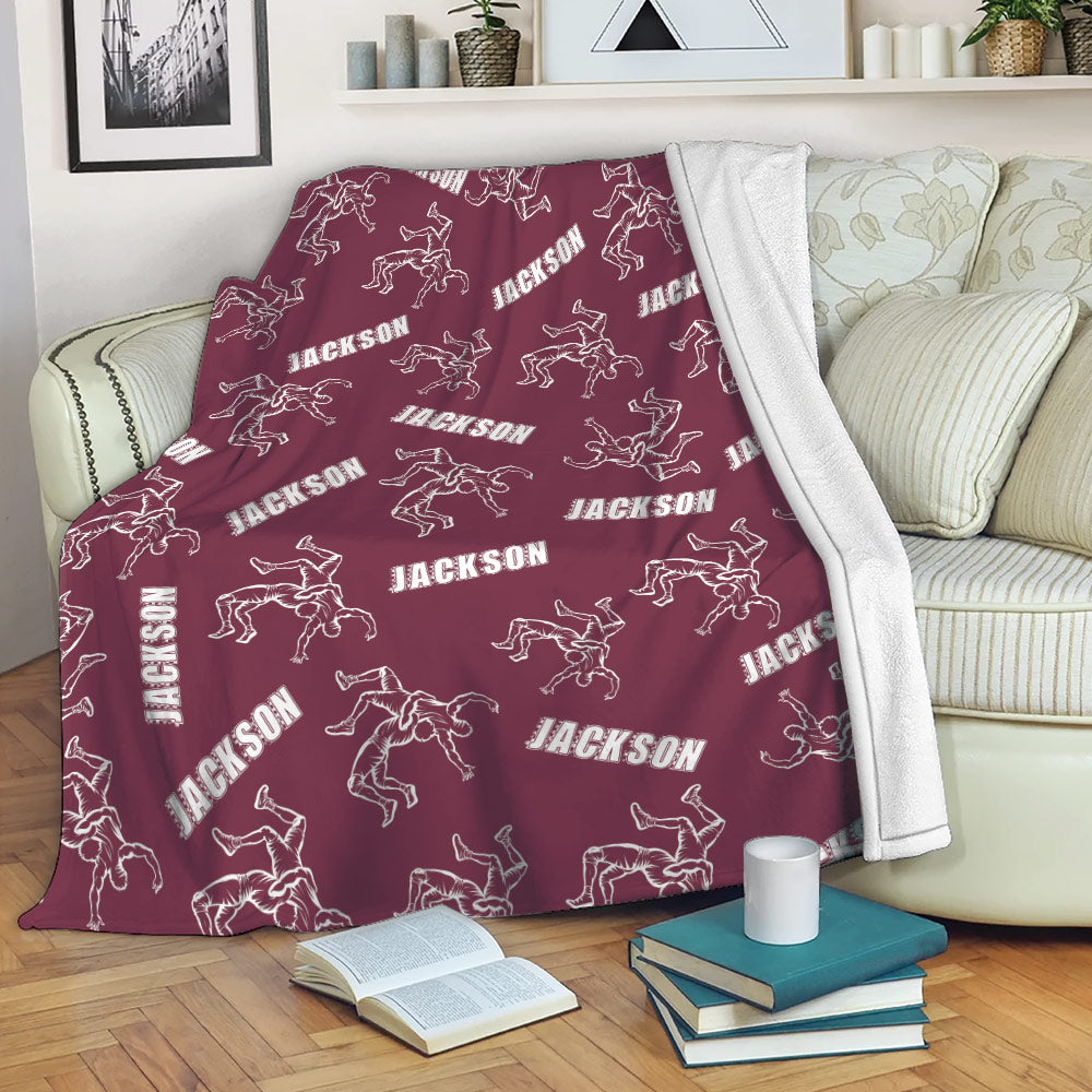 Maroon wrestling blanket draped over a couch with repeating grappling artwork