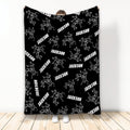 Black wrestling throw blanket featuring white illustrations of wrestlers in action