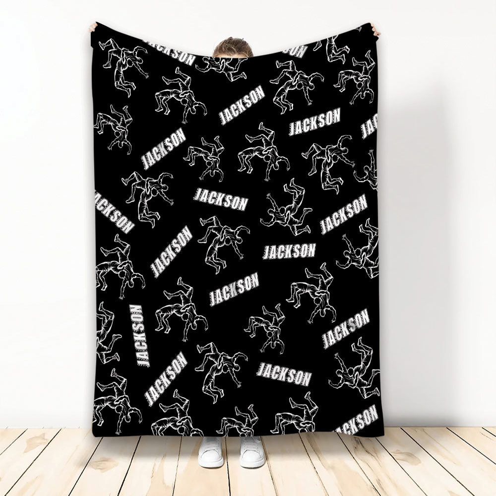 Black wrestling throw blanket featuring white illustrations of wrestlers in action