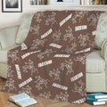 Brown wrestling blanket styled on a couch with repeating wrestling silhouettes