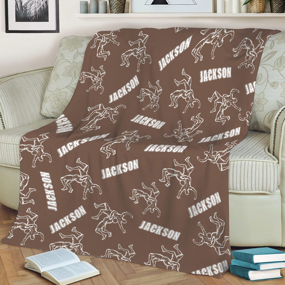 Brown wrestling blanket styled on a couch with repeating wrestling silhouettes