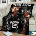 Football blanket draped over a couch featuring a helmeted player, football, and dramatic black and orange artwork