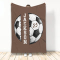 Brown soccer throw blanket featuring hand-drawn split soccer ball artwork and a bold athletic style