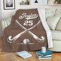 Custom hockey throw blanket draped over a sofa with crossed sticks and ball artwork