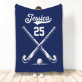 Navy hockey throw blanket featuring crossed sticks and a hockey ball design