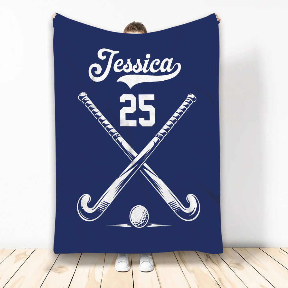 Navy hockey throw blanket featuring crossed sticks and a hockey ball design