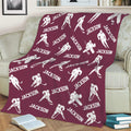 Maroon hockey throw blanket displayed on a sofa with repeating player and stick artwork