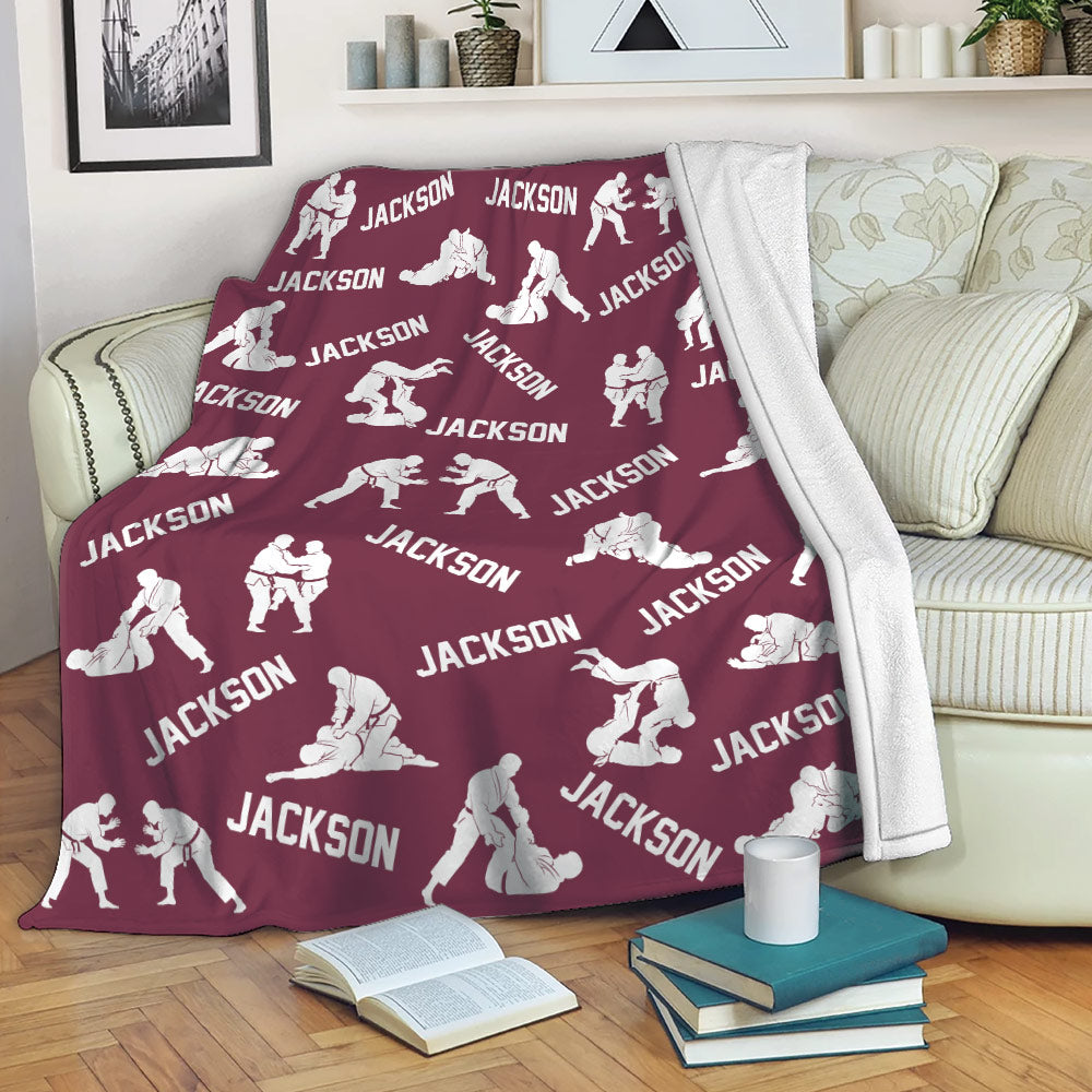 Jiu Jitsu throw blanket draped over a sofa with repeating grappling artwork in a deep maroon color