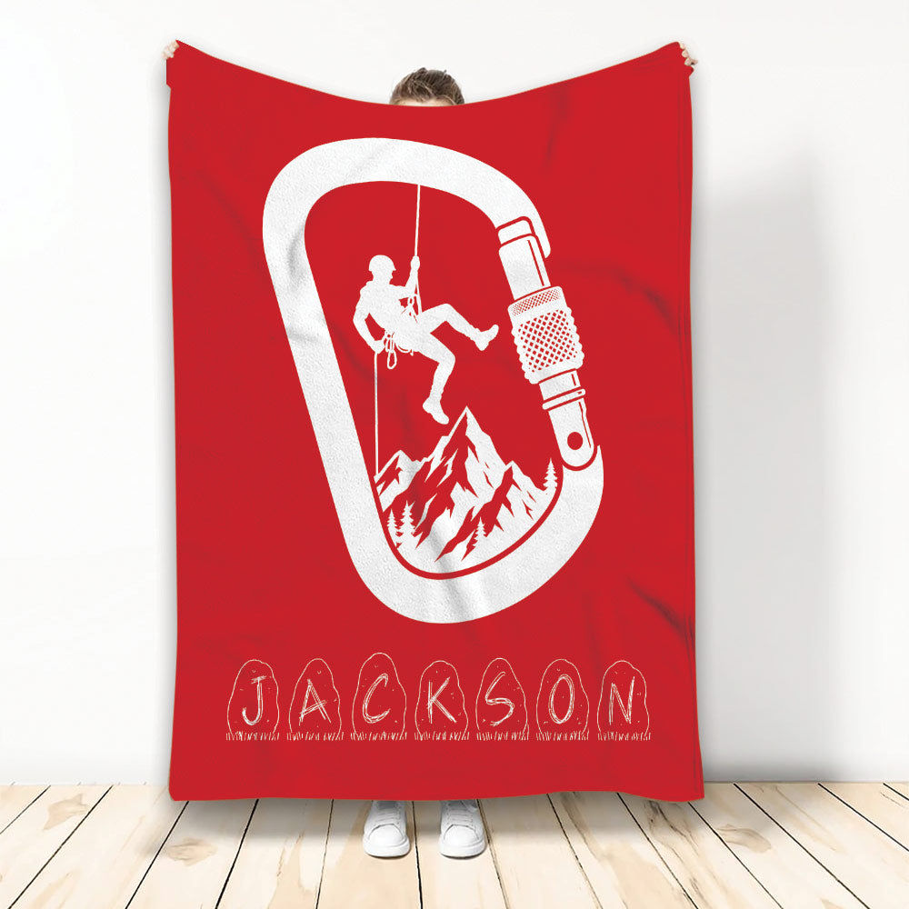 Red rock climbing blanket displaying a climber silhouette, mountain scene, rope, and large carabiner graphic