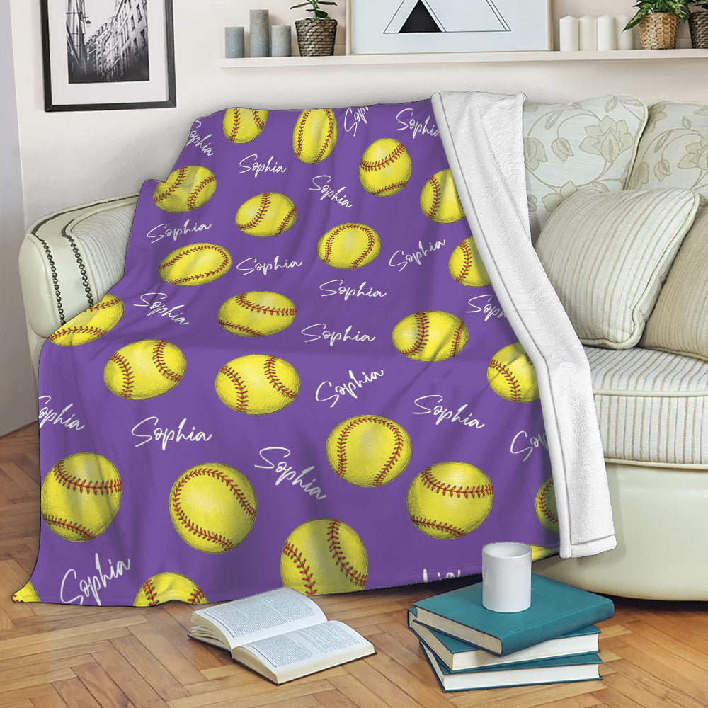 Purple softball throw blanket draped over a sofa with yellow softball artwork