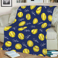 Navy blue softball throw blanket displayed on a sofa with yellow softball artwork