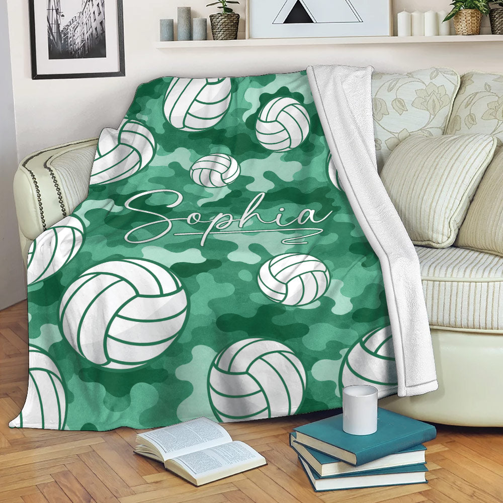 Green camouflage volleyball blanket styled over a sofa with repeating volleyball artwork