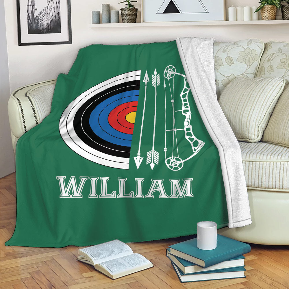 Green archery blanket draped over a sofa with target and bow artwork in a cozy living room