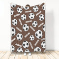 Brown soccer blanket shown upright with a repeating pattern of black and white soccer balls