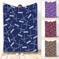 Hockey throw blanket with crossed sticks and pucks in a repeating navy, purple, maroon, and brown design