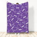 Purple hockey blanket displayed upright with white hockey sticks and pucks in an all-over pattern