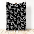 Black motocross throw blanket featuring a repeating white dirt bike rider pattern