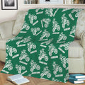 Green motocross throw blanket draped over a sofa with repeated dirt bike illustrations