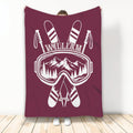 Maroon skiing blanket featuring crossed skis, ski goggles, poles, and a mountain landscape