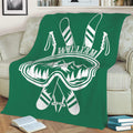 Green skiing throw blanket draped over a sofa with ski goggles, skis, poles, and mountains