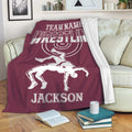 Maroon wrestling throw blanket draped over a sofa with bold lettering and dynamic grappling artwork