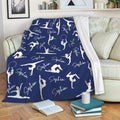 Navy gymnastics throw blanket draped over a sofa with white gymnast silhouettes