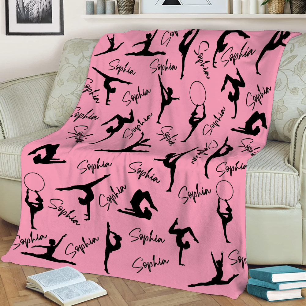 Pink gymnastics throw blanket with black gymnast silhouettes displayed on a sofa