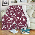 Maroon Taekwondo throw blanket with martial artist silhouettes draped over a sofa