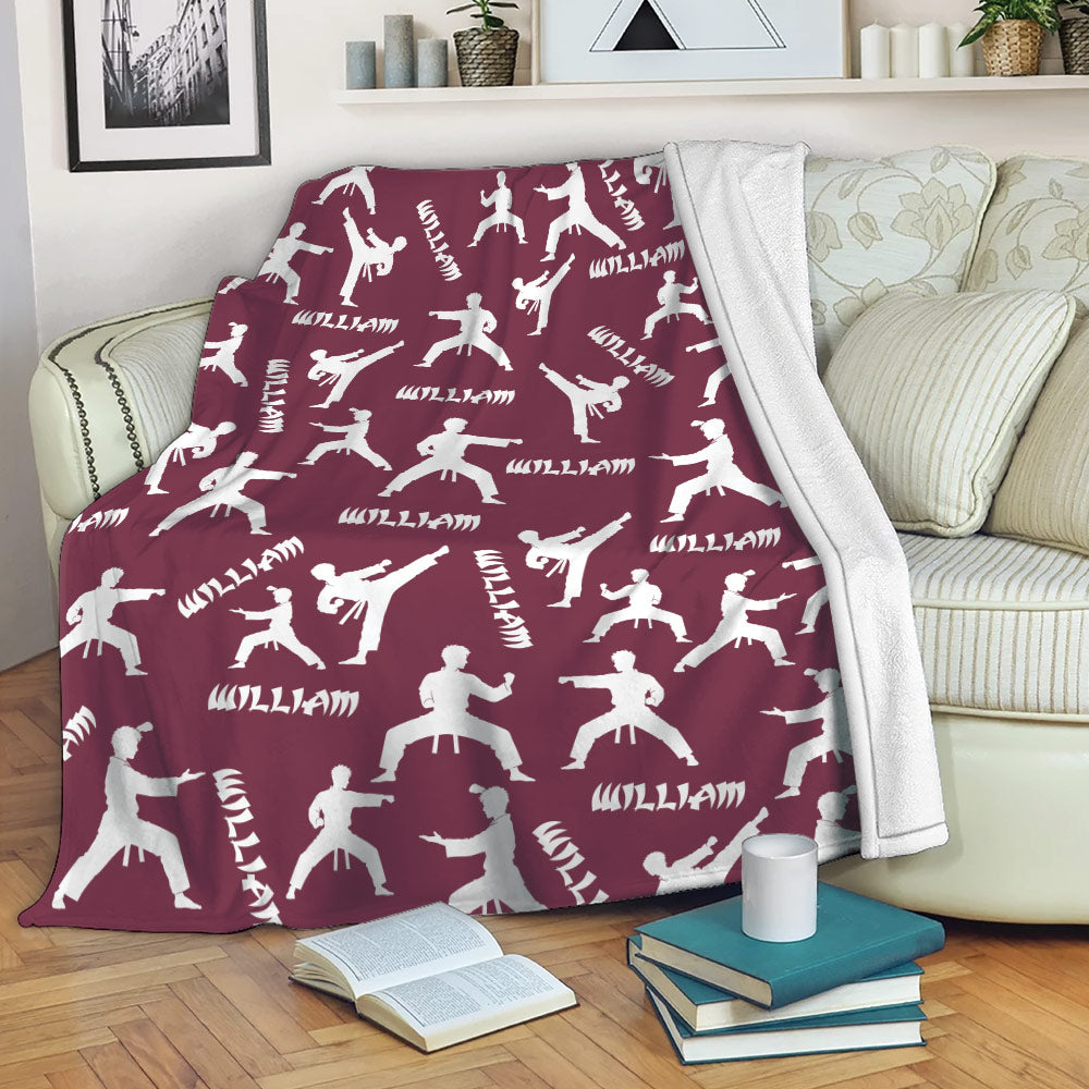 Maroon Taekwondo throw blanket with martial artist silhouettes draped over a sofa