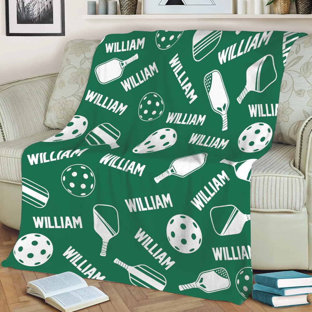 Green pickleball blanket spread across a couch with bold paddle and ball sports artwork