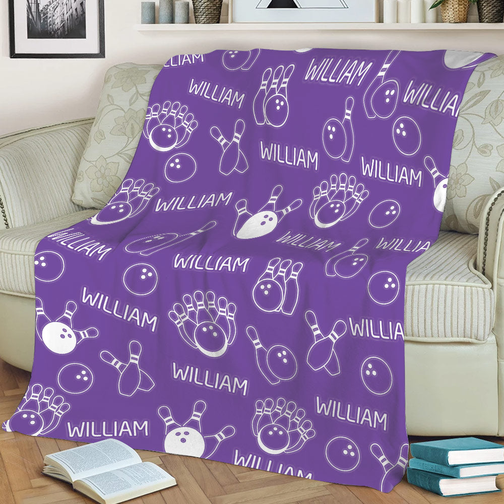 Purple bowling throw blanket styled on a sofa with bowling ball and pin illustrations