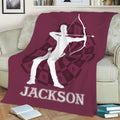 Maroon archery blanket displayed on a sofa with dynamic archer silhouette and target design