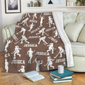 Brown hockey throw blanket styled on a sofa with repeating white player silhouettes and hockey sticks