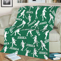 Green hockey throw blanket draped over a sofa with white hockey player silhouettes and sticks