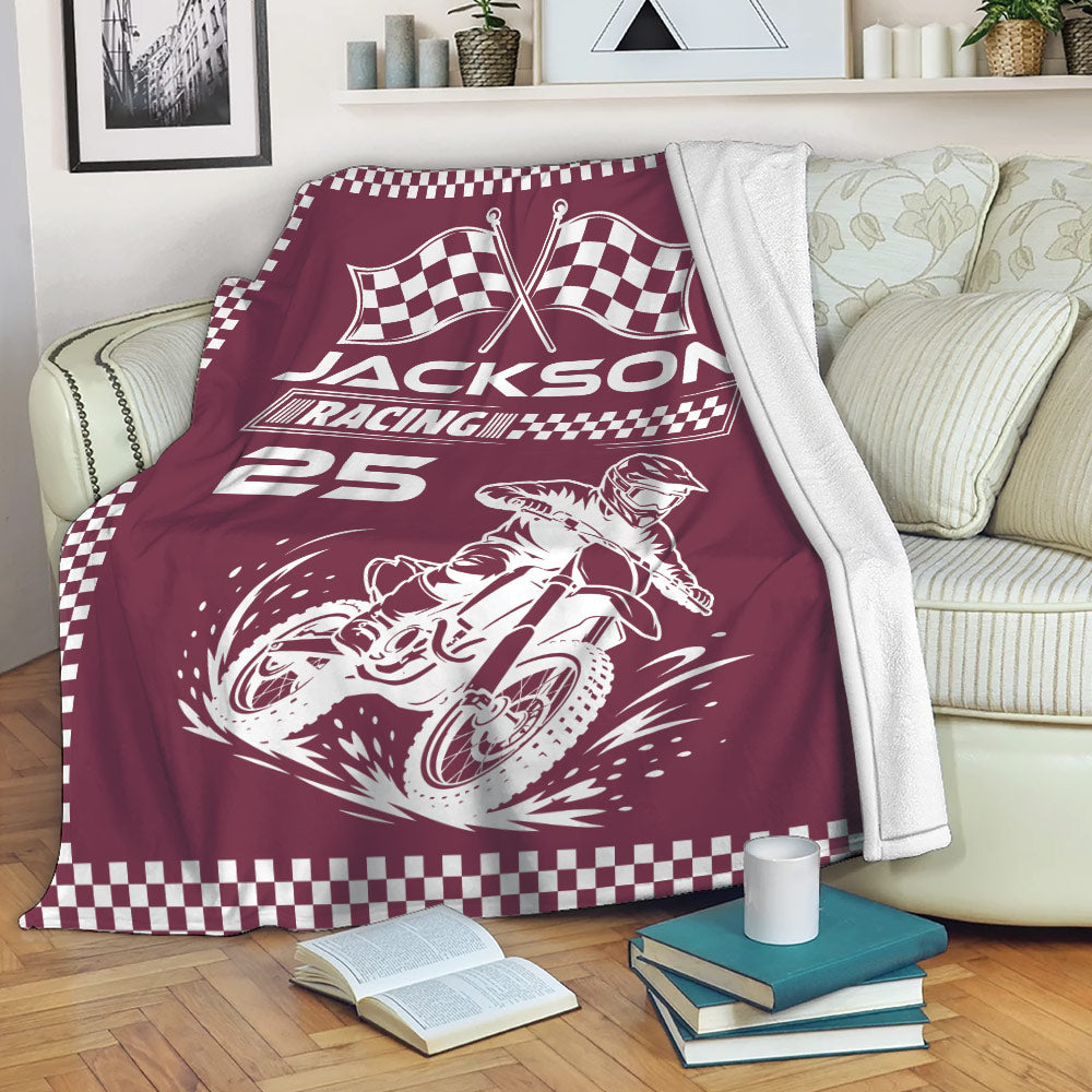 Maroon motocross blanket draped on a sofa with dirt bike racing artwork