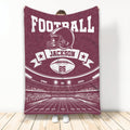Maroon football throw blanket featuring a helmet, football, stadium, and vintage sports design