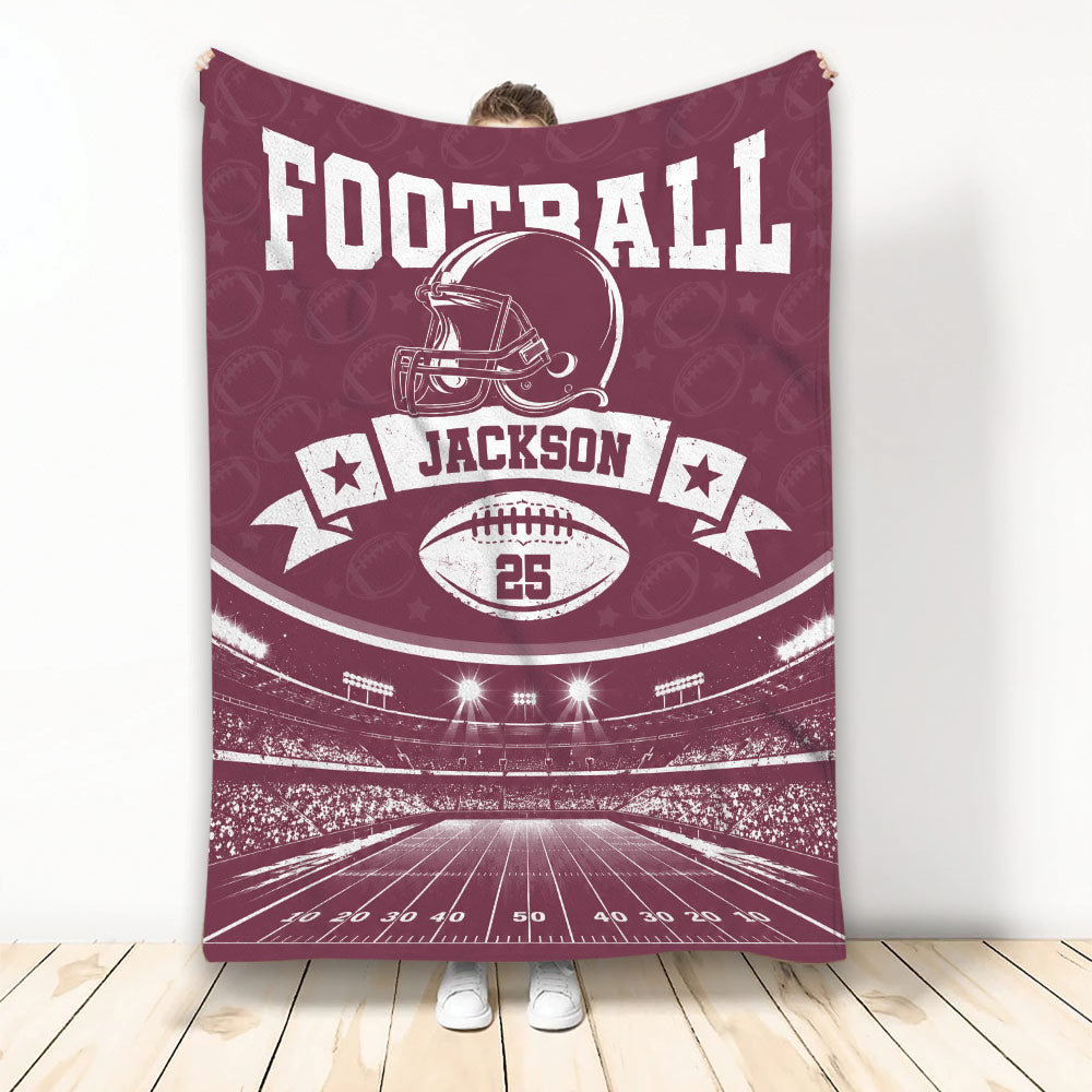 Maroon football throw blanket featuring a helmet, football, stadium, and vintage sports design