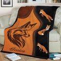 Rustic fox throw blanket draped over a couch with detailed orange fox illustrations