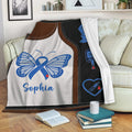 Diabetes awareness blanket displayed on a sofa with blue ribbon butterfly and glucose monitoring artwork