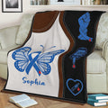 Diabetes throw blanket draped over a couch featuring blue awareness ribbon and blood glucose symbols